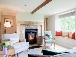 a living room with a fireplace and a chair at Corn Close in Stretton on Fosse