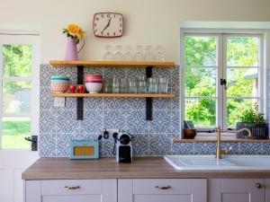 a kitchen with a counter and a clock on the wall at Corn Close in Stretton on Fosse
