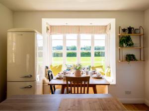 a kitchen with a table and a large window at Corn Close in Stretton on Fosse +17 photos