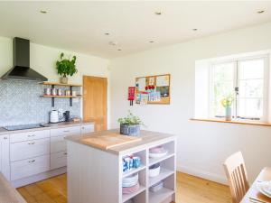 a kitchen with white cabinets and a counter top at Corn Close in Stretton on Fosse