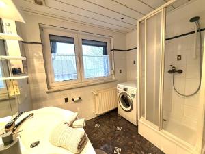 a bathroom with a sink and a washing machine at Ferienwohnung Am Blessberg in Stelzen in Eisfeld +17 photos