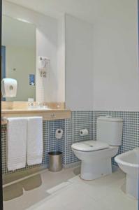 a bathroom with a toilet and a sink at Sercotel Murrieta in Logroño +16 photos