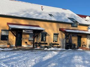 a building with snow on the ground in front of it at Weidelandfarm am Riebener See in Beelitz