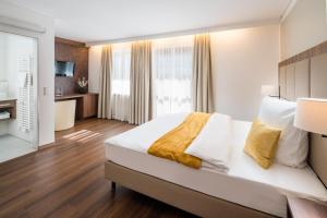 a bedroom with a large white bed and a bathroom at Hotel Lorenz in Bad Füssing +38 photos