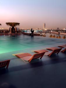 a swimming pool with several chairs in the water at World Heart Hotel in Baghdād