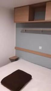 a black pillow sitting on top of a bed at ZEcamping 3 étoiles piscine chauffée toboggans pet friendly locatif TV 8 pers in Saucède