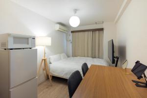 a hotel room with a bed and a table with chairs at Eruza HAKATA エルザ博多 in Fukuoka