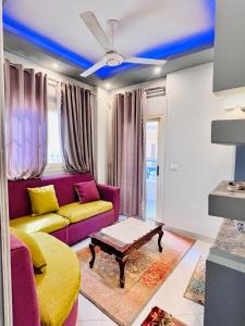 a living room with a purple couch and a table at Luxor apartment in Luxor