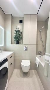a bathroom with a toilet and a sink and a tub at City Park Irpin - four in Irpin +7 photos