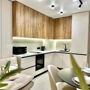 a kitchen with white cabinets and a table with chairs at City Park Irpin - four in Irpin