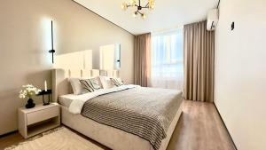 a bedroom with a large bed and a window at City Park Irpin - four in Irpin