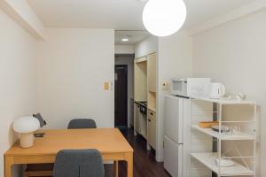 a kitchen with a table and chairs and a refrigerator at Eruza HAKATA エルザ博多 in Fukuoka