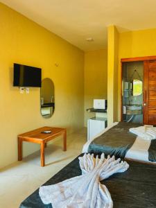 a hotel room with two beds and a table at Icaraizinho House in Icaraí