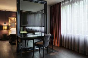 a desk in a hotel room with a mirror at Roomers Frankfurt Central, Autograph Collection in Frankfurt +52 photos
