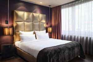 a bedroom with a large bed and a large window at Roomers Frankfurt Central, Autograph Collection in Frankfurt