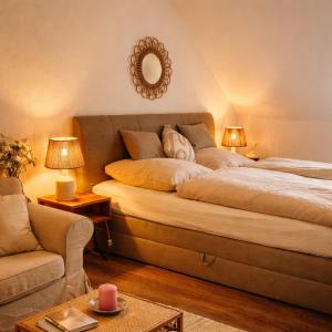 a bedroom with a bed and a couch and a mirror at Weidelandfarm am Riebener See in Beelitz +16 photos