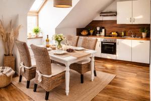a kitchen with a white table and chairs at Weidelandfarm am Riebener See in Beelitz