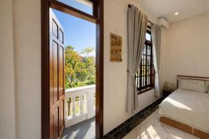 a bedroom with a bed and a large window at Cosy 2 Homestay in Hue