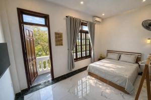 a bedroom with a bed and two large windows at Cosy 2 Homestay in Hue