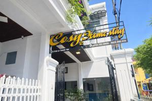 a white building with a sign for a store at Cosy 2 Homestay in Hue