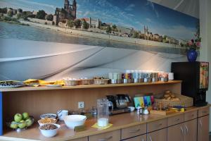 a kitchen counter with a large painting on the wall at sleep & go Hotel Magdeburg in Magdeburg +24 photos