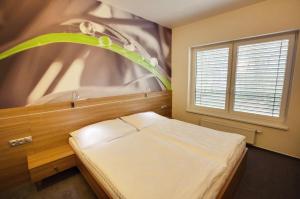 a small bedroom with a bed and a window at GREEN HOTEL Ostrava in Jáma František