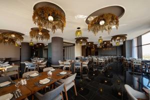 a dining room with tables and chairs and chandeliers at World Heart Hotel in Baghdād