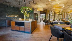 a restaurant with tables and chairs and a bar at Hotel Lautrup Park in Ballerup