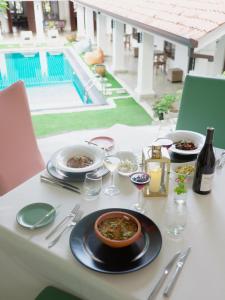a table with plates of food and a bottle of wine at La Maison de Colombo in Colombo