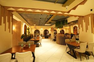 a restaurant with tables and chairs and a bar at Captains Crown Hotels & Resorts in Kushālnagar