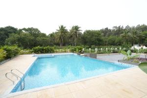 a large swimming pool with a wooden deck at Captains Crown Hotels & Resorts in Kushālnagar