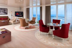a living room with a table and chairs at Herods Tel Aviv By The Beach in Tel Aviv