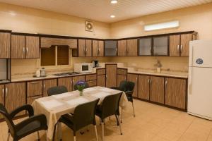 a kitchen with a table and chairs and a refrigerator at شقةكبيرة 4 غرف نوم وصالة بلكونه Large apartment with 4 bedrooms, a living room and a balcony in Taif