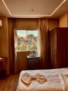 a hotel room with a bed with a bow tie on it at Crown pyramids hotel in Cairo +31 photos