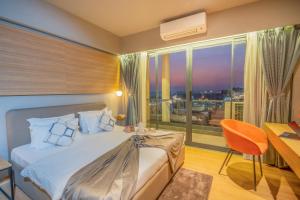 a bedroom with a bed and a desk and a window at The Vilton in Raipur