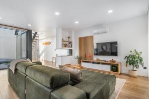 a living room with a couch and a tv at Dune House - Villa With Private Dune and Sea View in Viana do Castelo