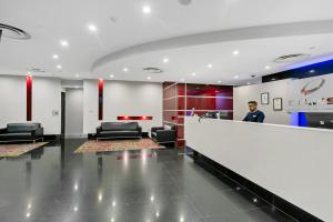 a man standing behind a counter in a waiting room at Urban Oasis City 2 Bed Apartment Oaks Horizons in Adelaide +26 photos