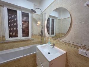 a bathroom with a sink and a tub and a mirror at Be Your Home - Cruise Stop Guest House in Civitavecchia