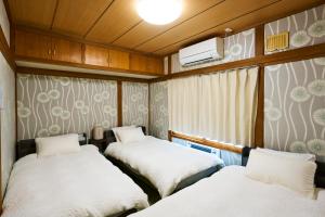 a small room with two beds and a window at Imari in Asahikawa