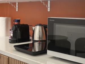 a kitchen counter with a coffee maker and a microwave at Be Your Home - Cruise Stop Guest House in Civitavecchia