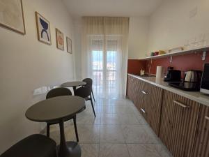 a kitchen with two tables and chairs in a room at Be Your Home - Cruise Stop Guest House in Civitavecchia