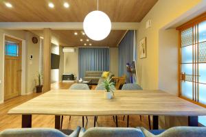 a living room with a large wooden table and chairs at Imari in Asahikawa