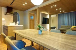 a dining room with a wooden table and chairs at Imari in Asahikawa