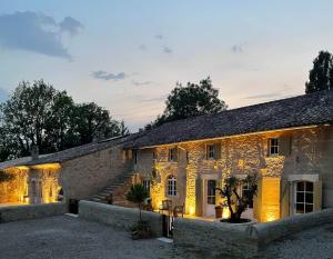 an old stone building with lights on at Maison Girardine in Rauzan