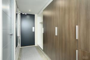 a hallway with a black door and wooden walls at Timantti Apartments by Hiekka Booking in Kalajoki