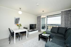a living room with a couch and a table at Timantti Apartments by Hiekka Booking in Kalajoki