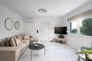 a white living room with a couch and a table at Alea Villa in Ierapetra