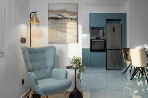 a living room with a blue chair and a kitchen at Alea Villa in Ierapetra
