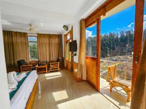 a bedroom with a bed and a large window at Purnima Little Italy in Manāli