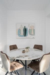 a white dining room table with chairs and a painting at Alea Villa in Ierapetra